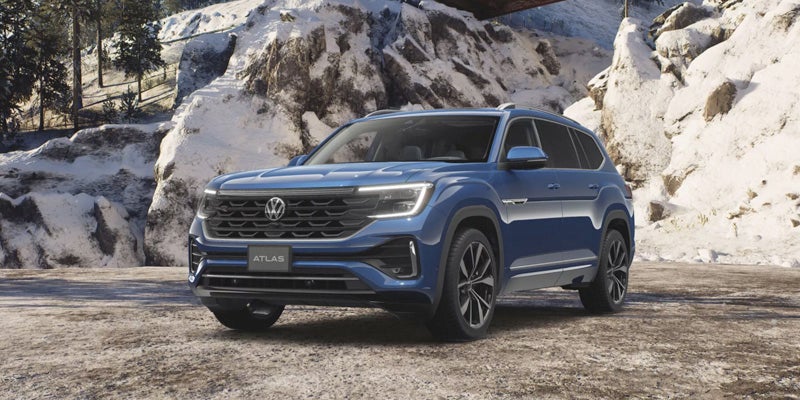 Blue Volkswagen SUV parked in snowy mountain setting