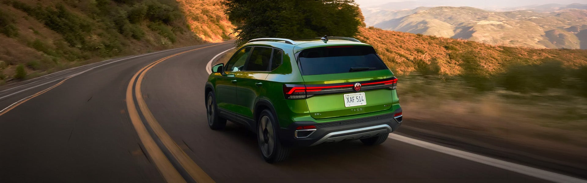 Rear view of green Volkswagen SUV driving on road