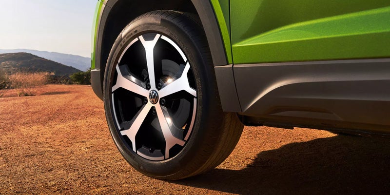 Close-up of Volkswagen alloy wheel on green SUV
