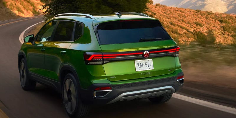 Rear view of green Volkswagen SUV driving on road