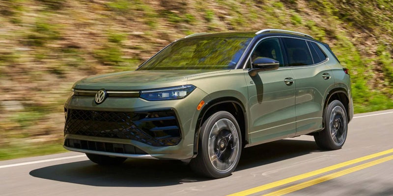 Green Volkswagen SUV front side view on road